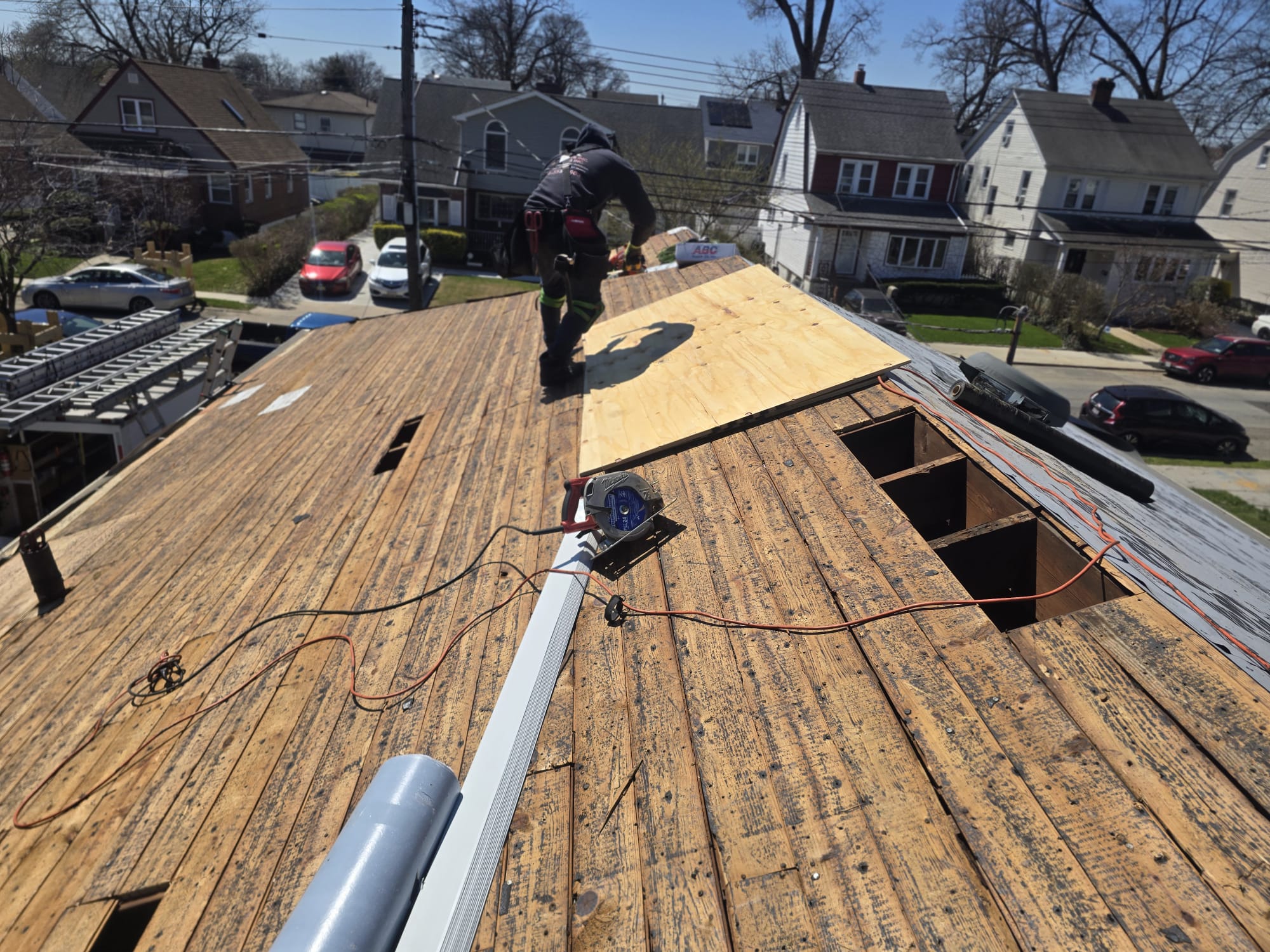 North Star roofing worker in a black shirt actively working on a residential roof